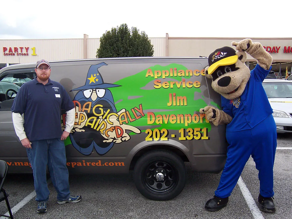 Jim with the original Magically Repaired van and a mascot